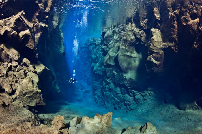 underwater photo, underwater photo diving, extreme diving photo: This american diver swims between the eurasian and north american tectonic plates in Silfra Canyon at Thingvellir National Park in Iceland, diving between eurasian and north american tectonic plates, best diving images, mystery places on earth, amazing places on earth, world's most beautiful places, This american diver  swims between the eurasian and north american tectonic plates in Silfra Canyon at Thingvellir National Park in Iceland. Photo: Alexander Mustard, extreme diving photo, extreme diving in Silfra Canyon at Thingvellir National Park in Iceland, photo of Silfra Canyon at Thingvellir National Park in Iceland diving, plate tectonic diving, swimming between plate tectonics photo, underwater photo: This american diver swims between the eurasian and north american tectonic plates in Silfra Canyon at Thingvellir National Park in Iceland