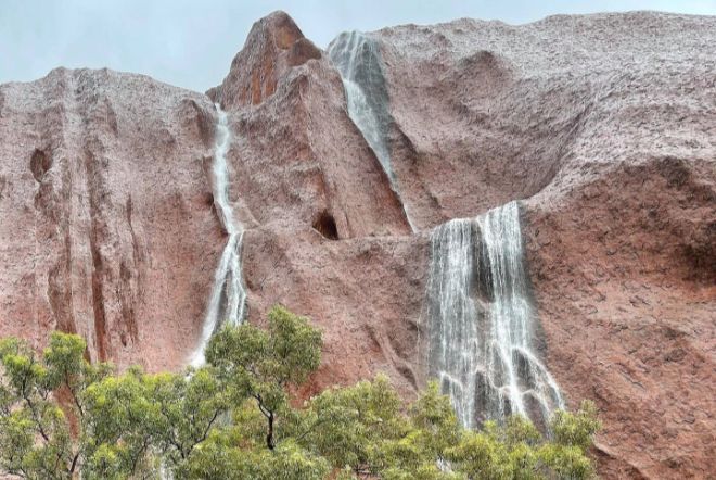uluru waterfalls, uluru waterfalls video, uluru waterfalls pictures, Waterfalls cascade down Uluru as severe weather brings heavy rain to Nothern Territory in Australia