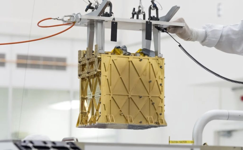 Technicians at NASA's Jet Propulsion Laboratory lower the Mars Oxygen In-Situ Resource Utilization Experiment (MOXIE) instrument into the belly of the Perseverance rover.
