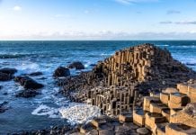 The Giant’s Causeway: Proof of Mythical Giants—or Just an Ancient Lava Flow in Ireland? Giant’s Causeway, basalt columns, Northern Ireland, volcanic formation, myth of giants, Basalt stone columns of the Giant’s Causeway leading into the Atlantic Ocean.