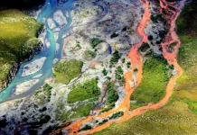 The Surprising Reason Why Arctic Rivers Are Turning Rusty Orange Rust-colored Arctic river meandering through tundra under a cold sky